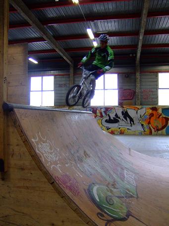 Thomas se projette en haut de la rampe pour attérir de travers sur ses deux roues